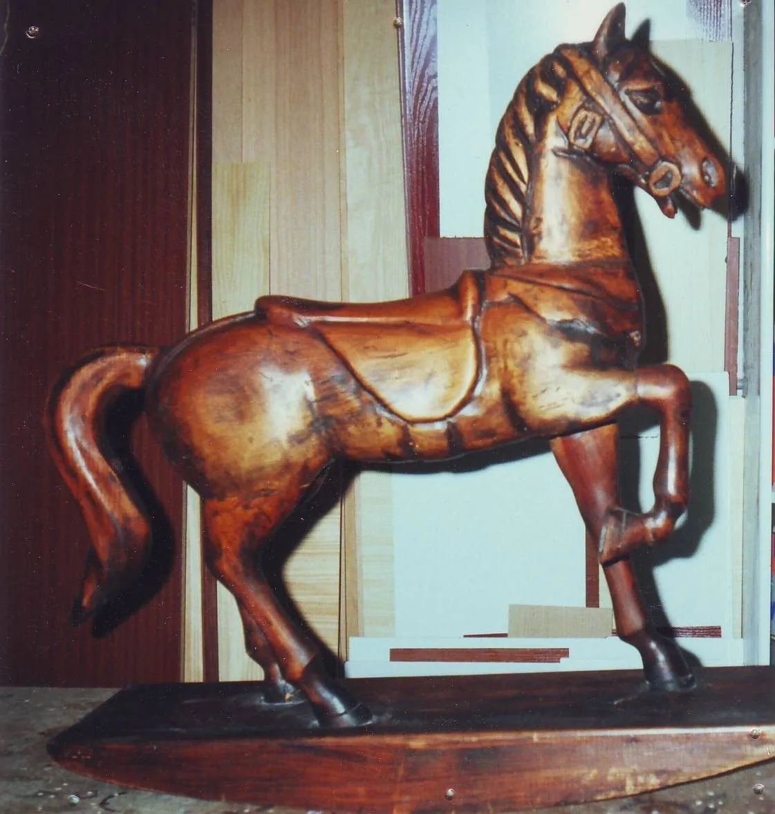 Caballo de juguete tallado en madera, sobre una peana