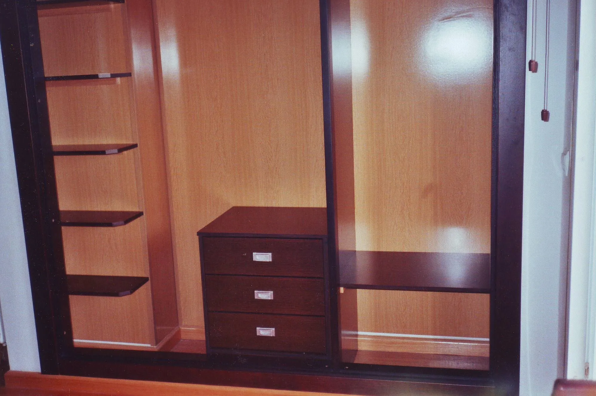 Interior de ropero con baldas, cajonera y barra en dos colores de madera