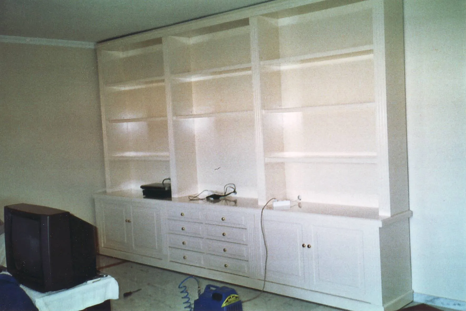 Librería lacada en blanco de pared a pared, con cajones abajo