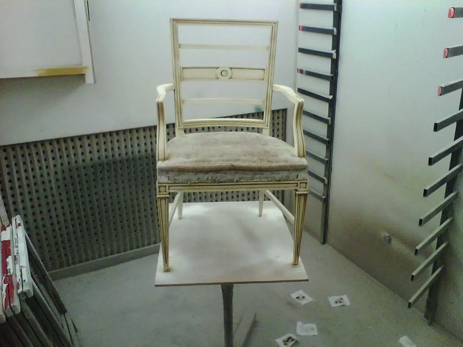 Sillón de madera clara durante la restauración, sin tapizar