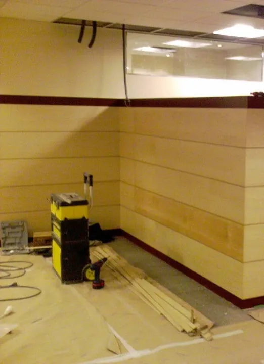 Separador de madera clara en una oficina, durante el montaje