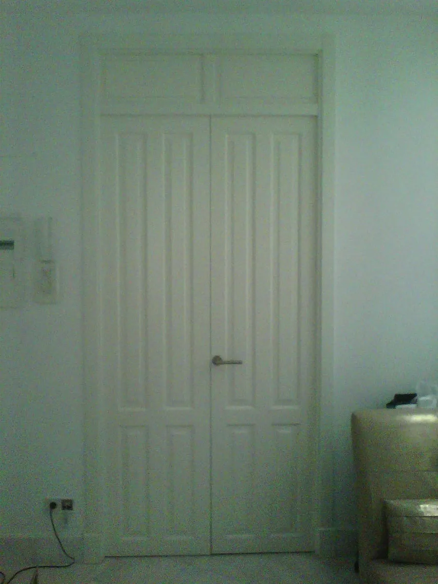 Puerta doble lacada en blanco de gran altura, con montante