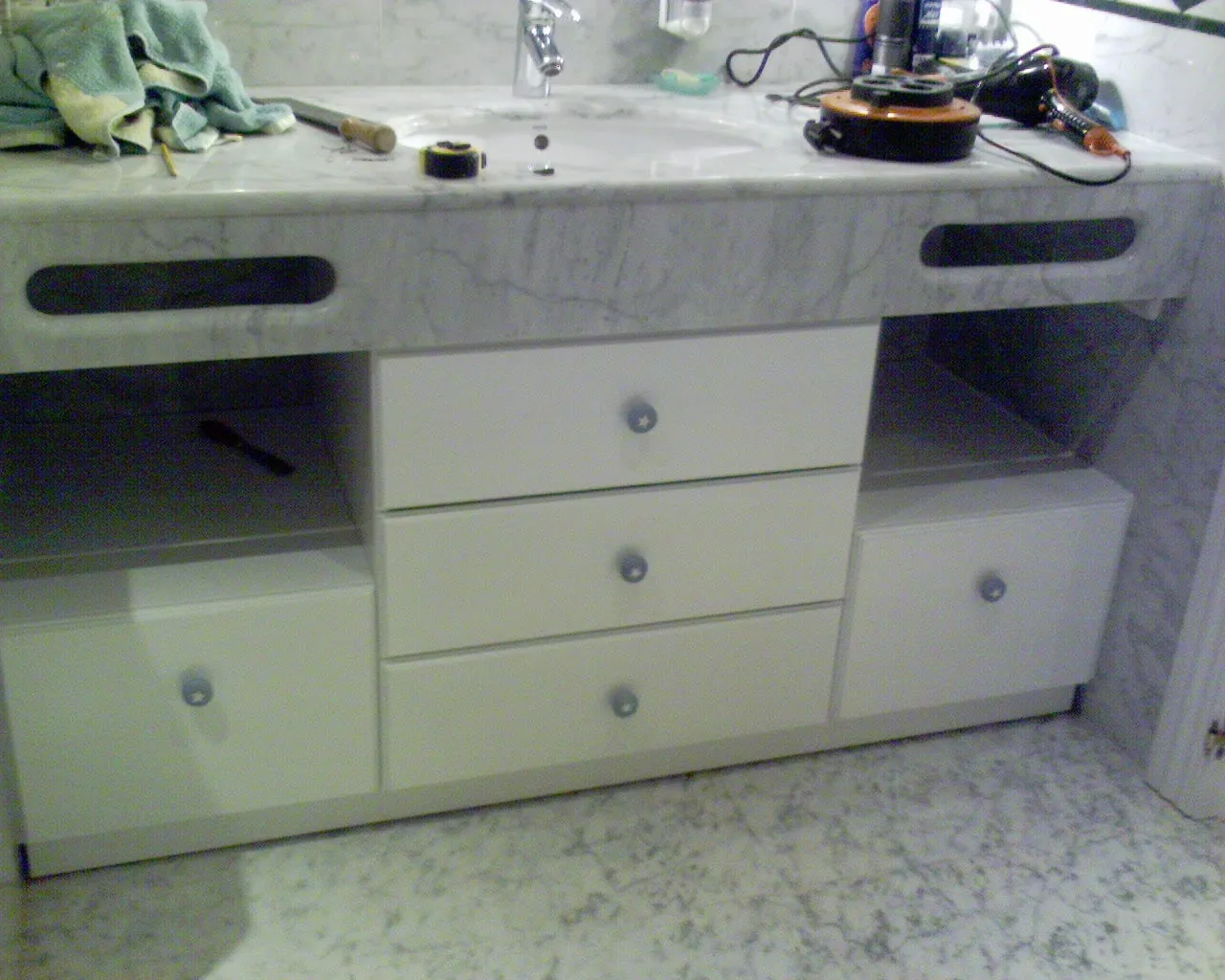Mueble de lavabo blanco con cajones bajo encimera de mármol